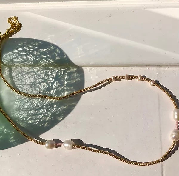A gold beaded necklace with ethically-sourced fresh water pearls.